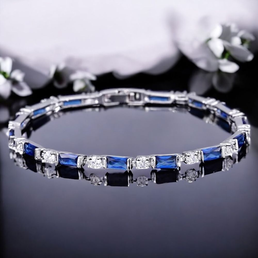 Smalle armband met saffierblauwe en heldere geslepen kristallen, op een zwarte ondergrond