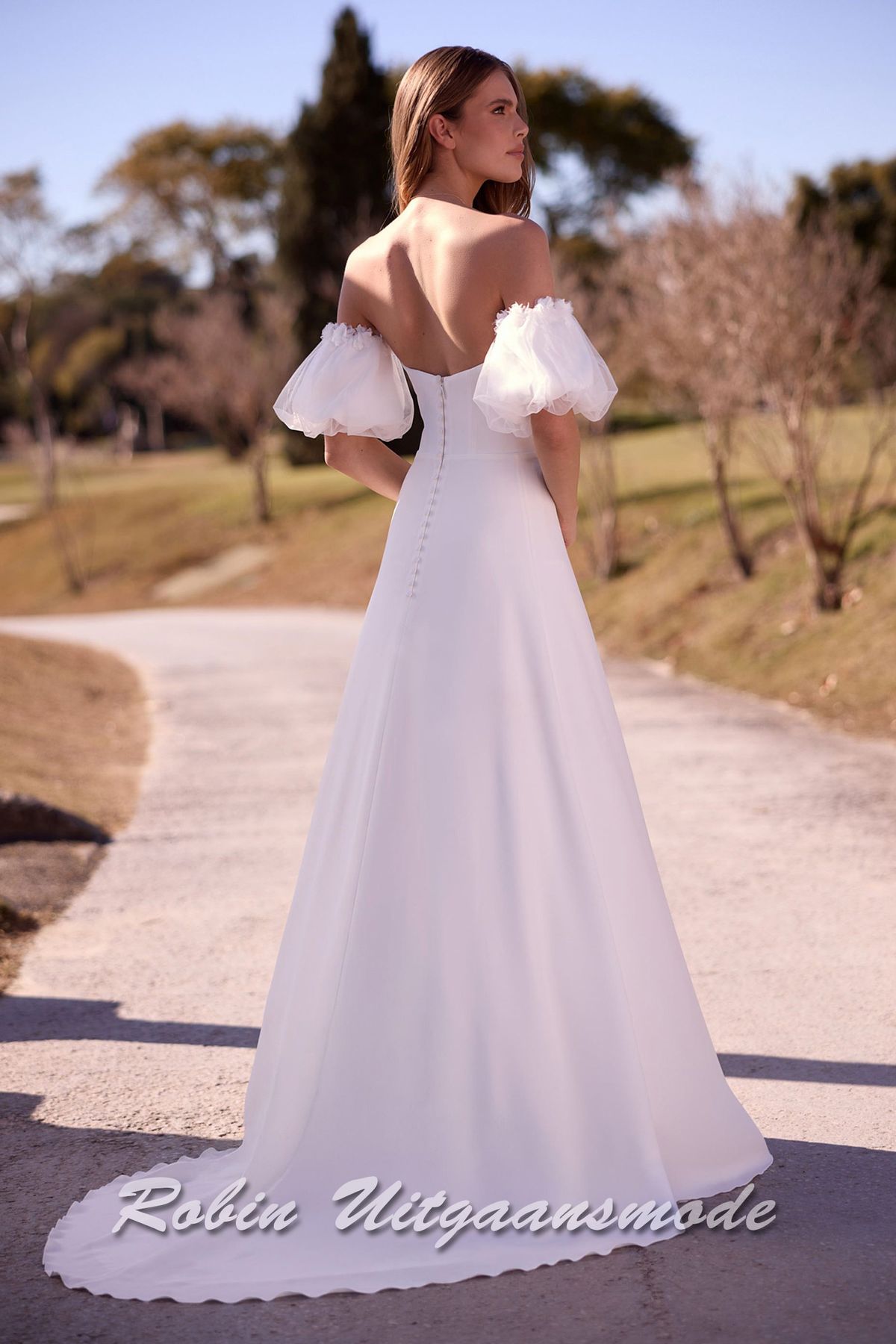 Achterzijde van de Strapless trouwjurk met een heartshape halslijn, losse pofmouwtjes van chiffon en een A-lijn rok met lange sleep