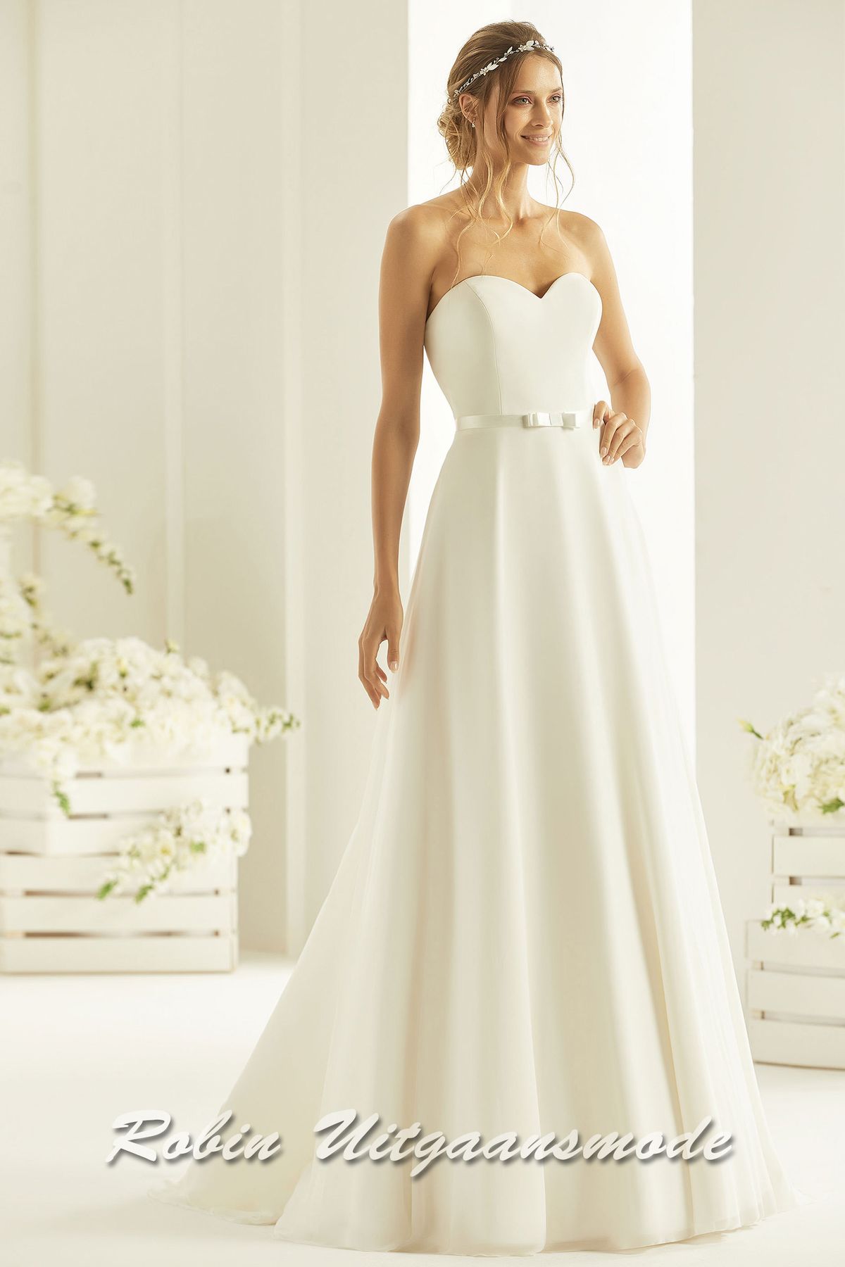 Eenvoudige trouwjurk met strapless lijfje, een sweetheart halslijn en een A-lijn rok met kleine sleep