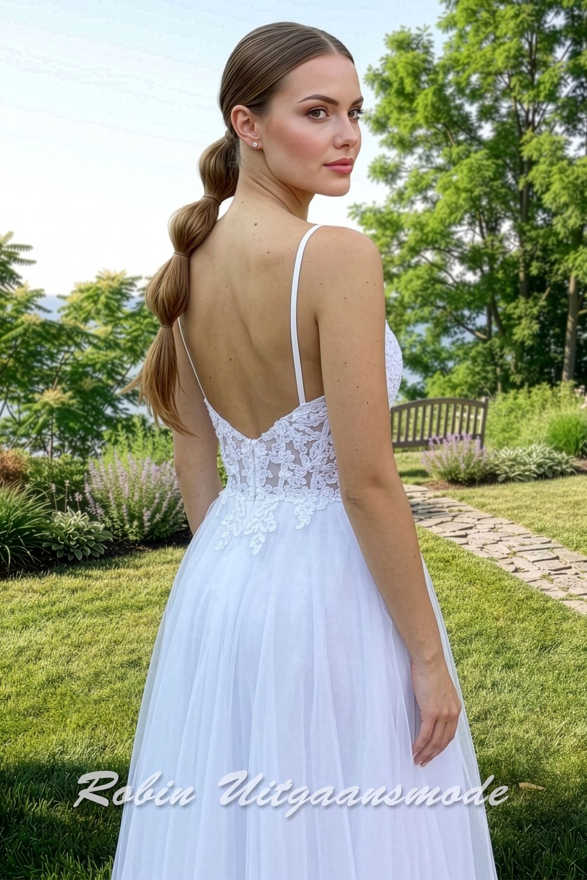Achterkant van de Witte trouwjurk met tule rok, een korset lijfje bedekt met kant, semi transparante taille en smalle bandjes.
