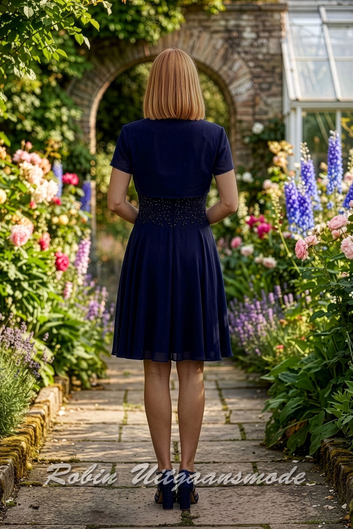 Achterkant van de Korte navy blauw avondjurk met glitterlijfje, chiffon rok en jasje