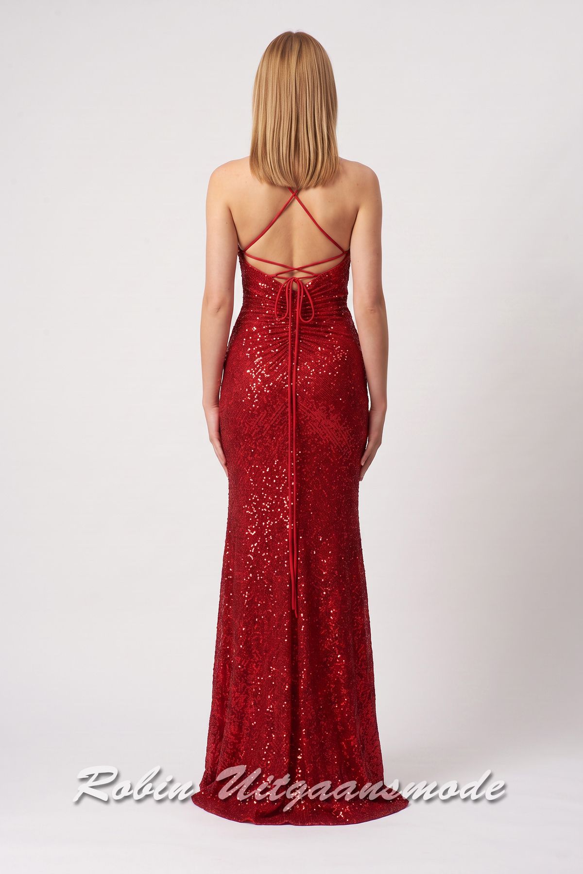Achterkant van de Rode glitterjurk in een aansluitend model met hoge split, een geplooid lijfje met V-hals en spaghettibandjes