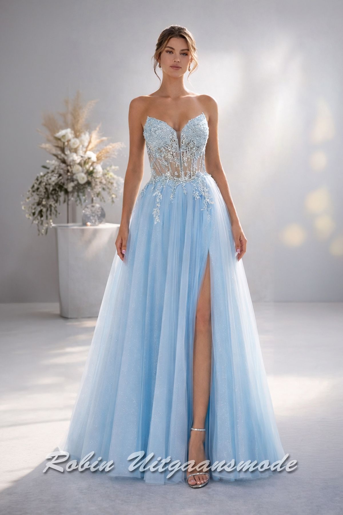 Lichtblauwe galajurk strapless korset lijfje, fleurige bloemversiering over de top en  A-lijn tule rok met hoge split