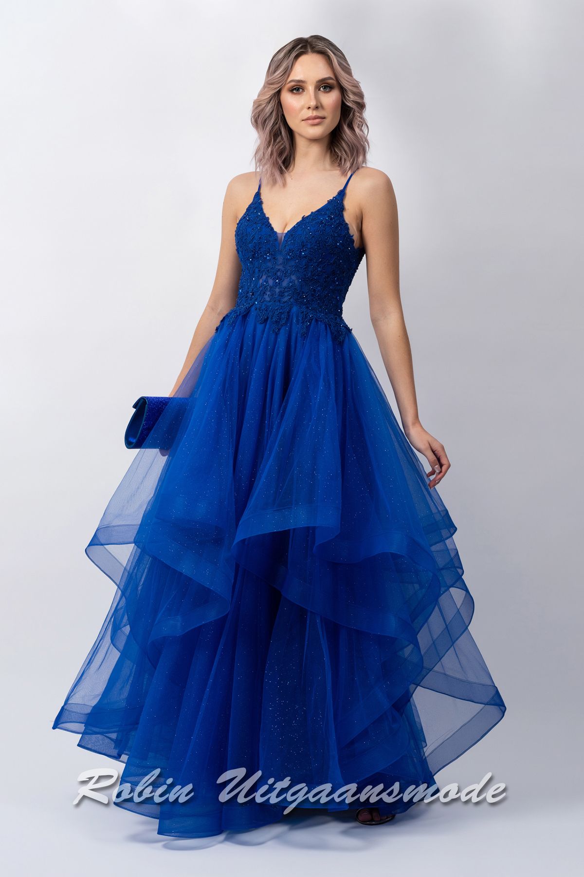 Royalblauwe galajurk met kanten lijfje, smalle bandjes, en een speelse rok met asymmetrische soft tule lagen