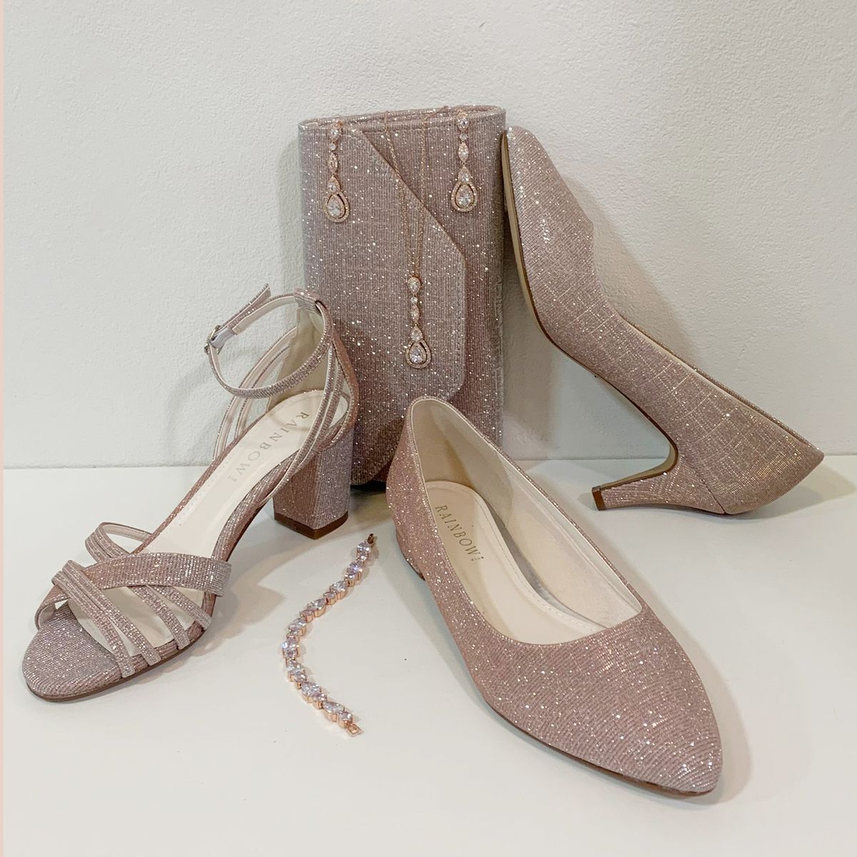 Sprankelende rosé-goud kleurige accessoires voor bij je jurk, met drie type schoenen, een avondtasje en sieradenset