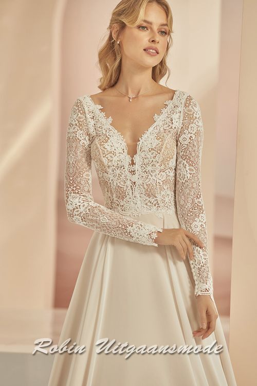 Close-up van de Grote maat trouwjurk met een lijfje en lange mouwen van kant