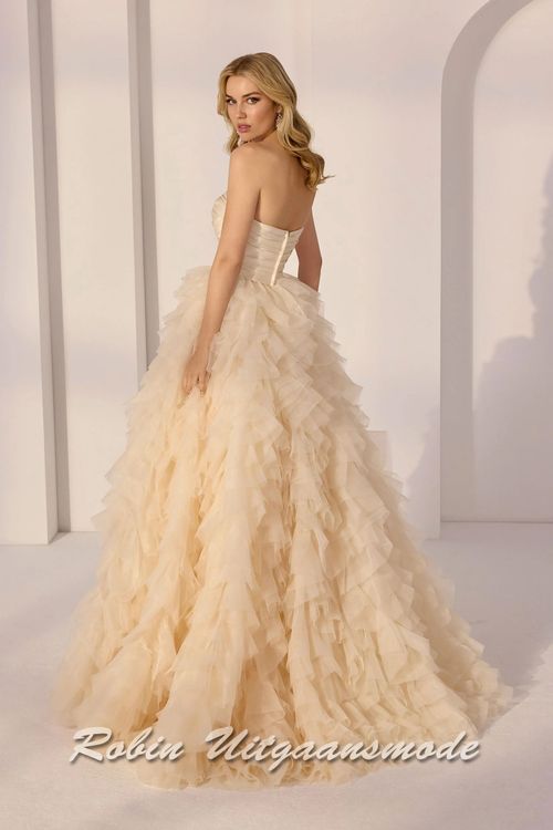 Achterkant van de Champagnekleurige baljurk met strapless lijfje met sweatheart hals lijn, gedrapeerd satijnen en een geplooide A-lijn rok met een cascade van lagen tule en organza