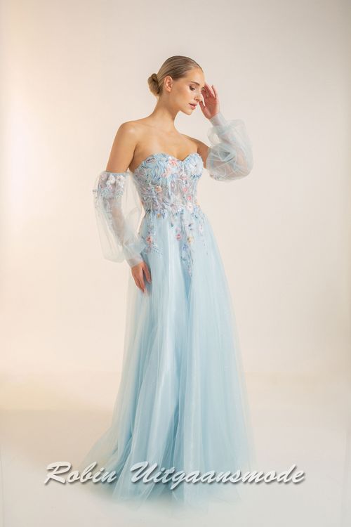 Strapless lichtblauwe galajurk met bloemen lijfje, losse pofmouwen van tule en springerige rok van soft tule
