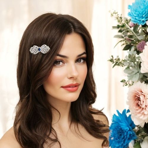 Extravagante haarclip in strikvorm met saffierblauw kristal, worn by a model